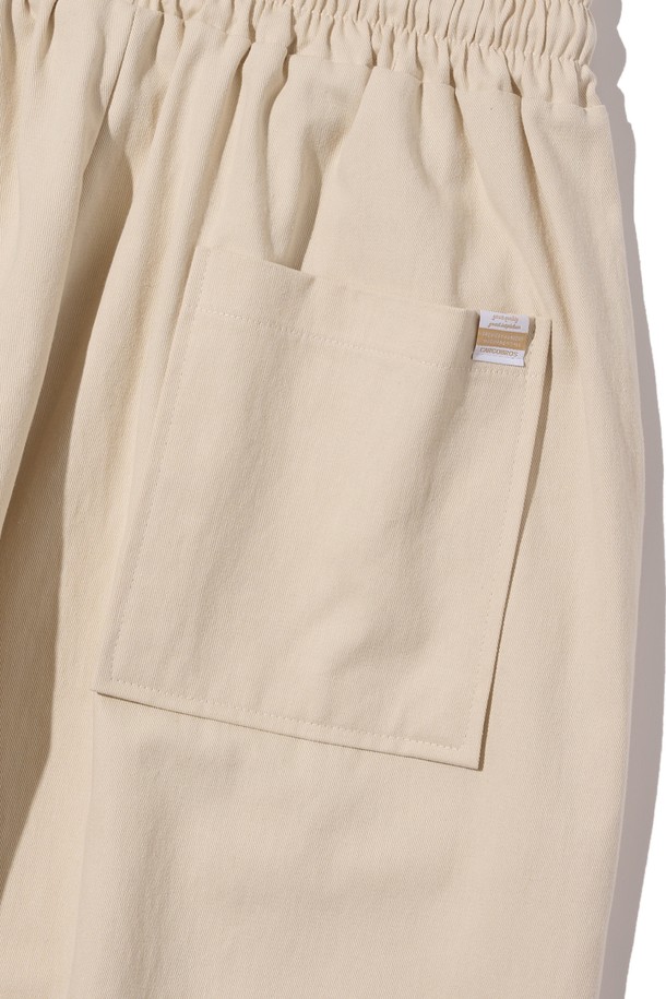 부드러운 면 소재로 제작된 아이보리 컬러의 밴딩 와이드 팬츠입니다. 베이직하고 캐주얼한 스타일로, 사계절 내내 편안하게 착용 가능한 루즈핏의 긴바지입니다. 밴딩 처리로 편안한 착용감을 제공하며, 드레이프성이 좋아 자연스러운 실루엣을 연출합니다.
