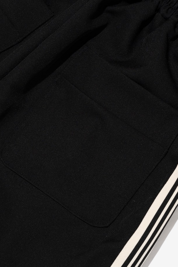 **투턱 테이핑 트레이닝 트랙팬츠 (블랙)**

일상과 스포츠 활동에 모두 적합한 남성용 트레이닝 팬츠입니다. 넉넉한 와이드핏과 긴 기장으로 편안함과 스타일을 동시에 잡았습니다. 폴리에스터 소재로 제작되어 활동성이 높고, 사이드 스트라이프 테이프와 투턱 디테일이 스포티하면서도 스트릿한 무드를 연출합니다. 밴딩 허리 디자인으로 편안한 착용감을 선사하며, 봄, 여름 시즌에 시원하게 입기 좋습니다. 동네 마실룩이나 여행룩으로 활용하기 좋은 캐주얼한 매력의 트레이닝 팬츠입니다.
