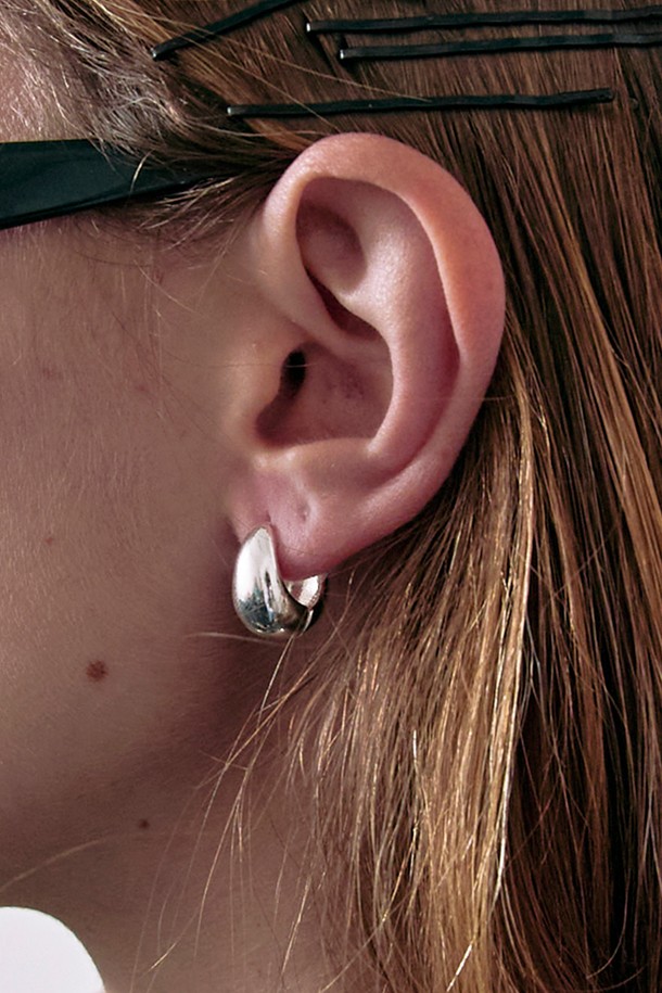 미니멀한 스타일의 Water drop 후프 귀걸이는 물방울 모양의 디자인과 심플한 디테일이 돋보이는 제품입니다. 알레르기 방지 기능이 있는 Brass 소재에 화이트 골드 도금 처리하여 데일리로 착용하기 좋습니다. 실버 색상의 후프형 디자인으로 세련된 느낌을 더했습니다.
