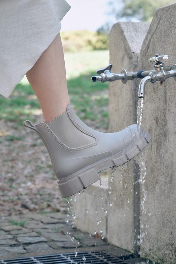 유비아 레인부츠 01 베이지 5cm는 여성용 레인부츠입니다. 베이지, 블랙, 아이보리 3가지 색상으로 출시되었으며, 일상 및 우천 시 모두 착용 가능합니다. 첼시 부츠를 모티브로 한 디자인으로 슬림한 앵클라인과 5cm 미들힐 굽이 특징이며, 세련된 토 쉐입으로 스타일리시함을 더했습니다. 합성고무와 PVC 소재로 제작되어 튼튼하며, 발볼은 11cm입니다. 앵클 탑라인과 고무 밴드 디자인으로 신고 벗기 편리하며, 미니멀, 클래식, 캐주얼 스타일의 여행룩에 잘 어울립니다.
