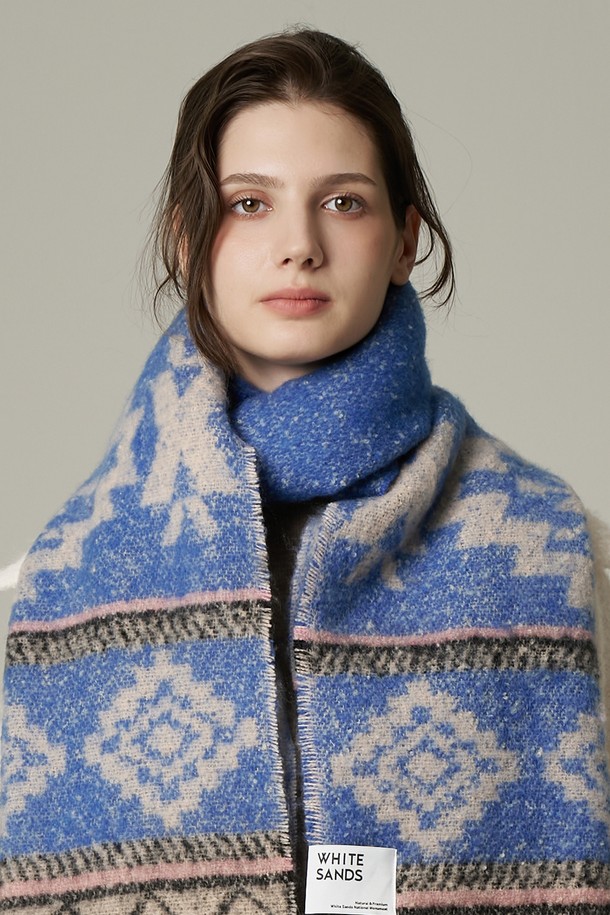 **에스닉 머플러 하르렘**은 울 소재로 제작되어 부드러운 촉감과 뛰어난 보온성을 자랑하는 여성용 머플러입니다. 가을과 겨울에 착용하기 좋으며, 블루, 베이지, 브라운 컬러의 기하학 패턴으로 에스닉한 스타일을 연출합니다. 두꺼운 두께감과 프린지 디자인 장식이 특징으로, 출근룩과 모임룩에 클래식, 에스닉, 캐주얼 등 다양한 스타일을 더할 수 있습니다.
