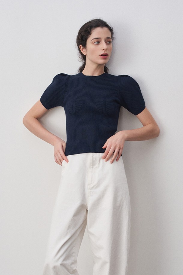 세련된 무드의 델라 퍼프 슬리브 니트 탑 네이비입니다. 부드러운 촉감의 울, 아크릴, 나일론, 폴리에스터 혼방 소재로 제작되어 간절기 시즌에 착용하기 좋습니다. 라운드넥 디자인에 레귤러핏으로 편안하게 착용 가능하며, 얇은 두께감으로 답답함 없이 즐길 수 있습니다. 퍼프 슬리브 디테일과 턱 주름이 여성스러운 실루엣을 연출하며, 립 조직과 뛰어난 신축성으로 활동성을 높였습니다. 데일리, 오피스, 포멀 룩에 모두 잘 어울리는 베이직하고 엘레강스한 스타일의 니트 탑입니다.
