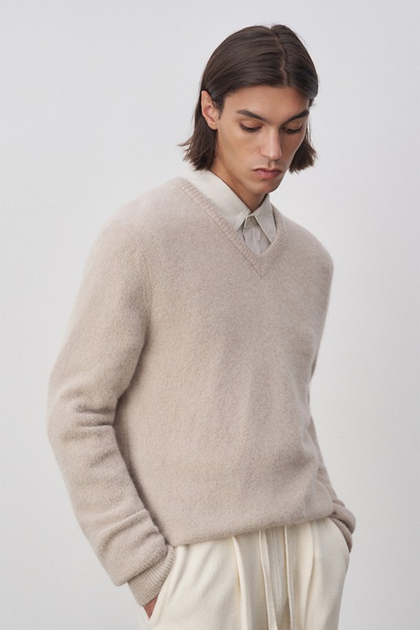 디오니 브이넥 수리 알파카 니트 탑 베이지는 부드러운 촉감과 은은한 광택이 특징인 알파카, 나일론, 스판덱스 혼방 소재의 니트입니다. 클래식하고 미니멀한 스타일로, 비즈니스 데일리룩, 오피스룩, 포멀한 자리에 활용하기 좋습니다. 브이넥 디자인과 레귤러 핏으로, 가을과 겨울에 따뜻하고 편안하게 착용할 수 있습니다. 수리 알파카 특유의 따가움을 개선하여 실크처럼 매끄러운 감촉을 선사하며, 자연스러운 드레이프 실루엣을 연출합니다. 두꺼운 두께감으로 뛰어난 보온성을 자랑하는 기본 니트 패턴의 긴소매 상의입니다.
