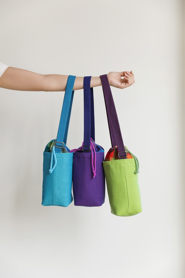 [오리고] 보온보냉 크로스 텀블러 백 물병 가방은 면과 PVC 소재로 제작되어 3가지 색상(사인머스컷 그린, 칸문 블루, 털란시아 퍼플)으로 제공됩니다. 미디엄 사이즈의 원통형 가방으로, 스트라이프 패턴과 복조리형 오픈 방식, 길이 조절 가능한 웨빙 스트랩이 특징입니다. 넉넉한 수납공간과 함께 보온, 보냉, 방수 기능을 갖춰 등산, 레저, 일상, 여행 등 다양한 용도로 활용할 수 있습니다. 조임용 끈으로 간편하게 잠글 수 있으며, 크로스백 형태로 편리하게 휴대 가능합니다.
