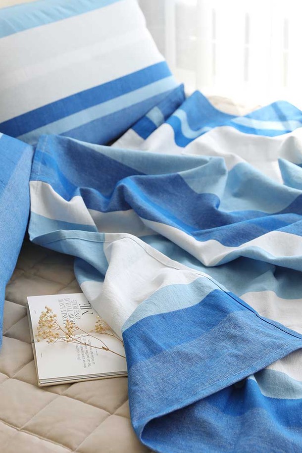 [오리고] 홑이불 겸 스프레드 160x215cm - 소파커버 퓨어스카이는 100% 유기농 수제 면으로 제작되어 부드러운 촉감을 자랑합니다. 시원한 스카이블루, 화이트, 실버그레이 색상의 스트라이프 패턴은 여름 하늘과 구름을 연상시키며, 미니멀한 스타일을 연출합니다. 흡습 기능이 있어 쾌적하게 사용할 수 있으며, 홑이불, 소파커버, 피크닉 매트 등 다용도로 활용 가능합니다. 세탁할수록 더욱 부드러워지는 특징을 가지고 있습니다. 160x215cm 사이즈로 제작되었습니다.
