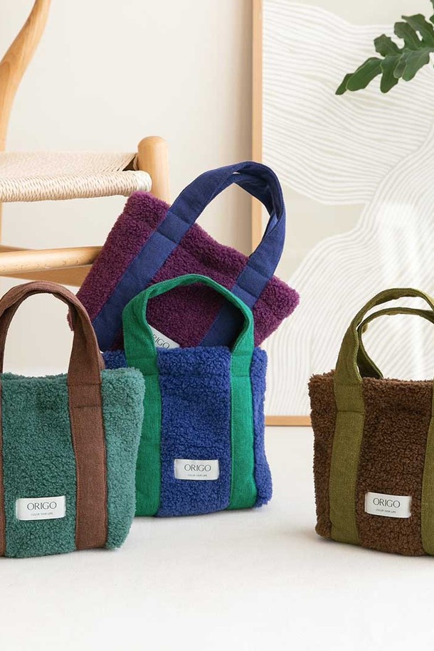 플리스 스퀘어 토트백 4컬러는 부드러운 플리스 소재로 제작되어 따뜻함과 편안함을 선사합니다. 미디엄 사이즈의 사각 토트백으로, 데이트룩, 모임룩, 출근룩 등 다양한 TPO에 활용하기 좋습니다. 미니멀, 클래식, 캐주얼 스타일 모두 소화 가능한 디자인이며, 4가지 다채로운 컬러 구성으로 폭넓은 선택지를 제공합니다. 심플한 디자인에 투톤 컬러 배색이 포인트로 들어가 세련된 분위기를 더합니다. 가방 내부에는 넉넉한 수납 공간과 손잡이가 있어 실용성을 높였습니다.
