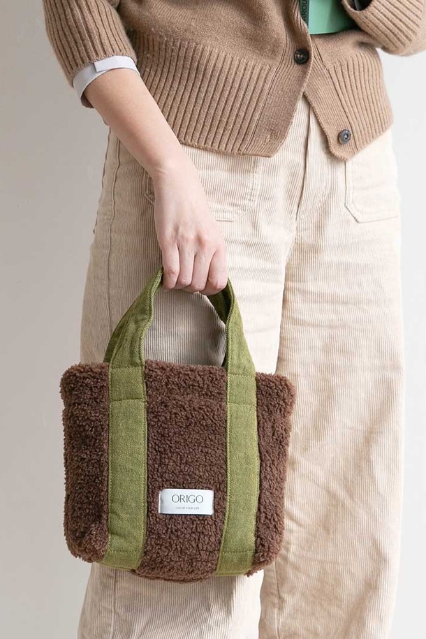 플리스 스퀘어 토트백 4컬러는 부드러운 플리스 소재로 제작되어 따뜻함과 편안함을 선사합니다. 미디엄 사이즈의 사각 토트백으로, 데이트룩, 모임룩, 출근룩 등 다양한 TPO에 활용하기 좋습니다. 미니멀, 클래식, 캐주얼 스타일 모두 소화 가능한 디자인이며, 4가지 다채로운 컬러 구성으로 폭넓은 선택지를 제공합니다. 심플한 디자인에 투톤 컬러 배색이 포인트로 들어가 세련된 분위기를 더합니다. 가방 내부에는 넉넉한 수납 공간과 손잡이가 있어 실용성을 높였습니다.
