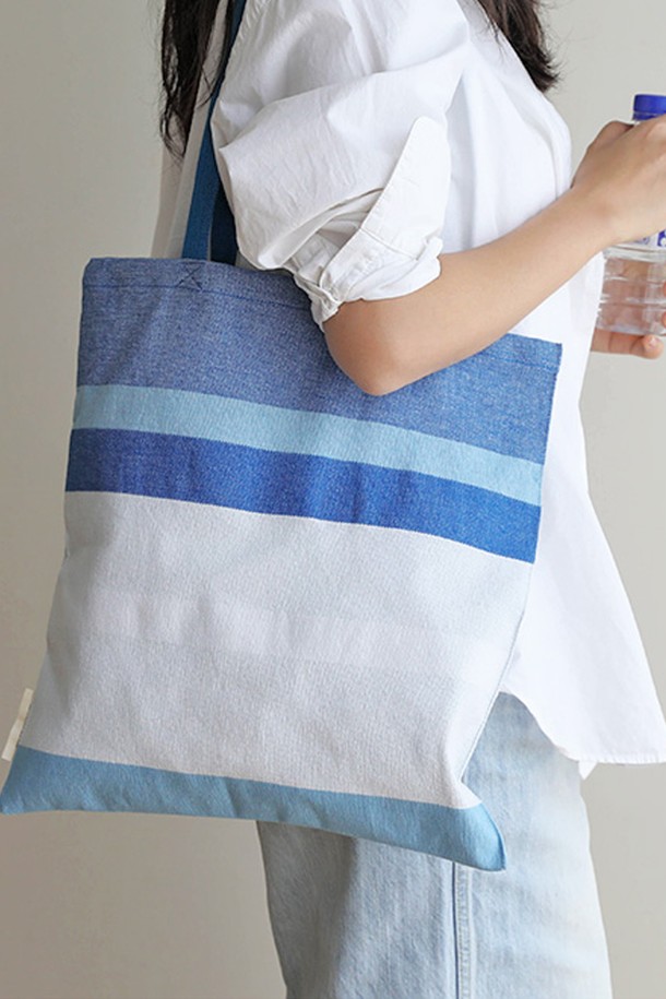 [오리고] 에코백 오가닉코튼 퓨어스카이 2종은 GOTS 인증을 받은 오가닉 코튼으로 제작되어, 무농약 3년 이상 재배된 순수한 면의 질감을 느낄 수 있습니다. 미디엄 사이즈의 사각 에코백으로, 스카이블루, 화이트, 실버그레이 3가지 색상에 스트라이프 패턴이 더해져 캐주얼, 미니멀, 클래식 스타일을 연출합니다. 자연스러운 직조 텍스처와 캔버스 두께감으로 내구성이 뛰어나며, 핸드룸 직조 방식으로 제작되어 A4 사이즈 수납이 가능합니다. 오픈형 디자인에 손잡이가 있어 동네 마실룩, 쇼핑룩, 산책룩 등 일상생활에서 편안하게 사용하기 좋습니다. 유해물질 없이 자연 염색된 오가닉 코튼 에코백으로, 소중한 당신의 하루를 더욱 특별하게 만들어 보세요.
