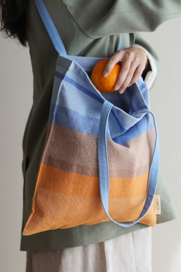 [오리고] 에코백 오가닉코튼 썬키스드워터 2종은 여성 및 남성 모두 사용 가능한 미디엄 사이즈의 에코백입니다. 블루와 베이지 두 가지 색상으로 제공되며, 오가닉 코튼 소재로 제작되어 부드러운 캔버스 두께감을 자랑합니다. A4 사이즈 수납이 가능하며, 손잡이가 있어 편리하게 사용 가능합니다. 미니멀하고 베이직한 디자인으로 쇼핑룩, 산책룩 등 다양한 TPO에 잘 어울립니다. GOTS 및 Oeko-tex Standard 100 인증을 받은 친환경 제품이며, 핸드메이드 수제 직조 방식으로 제작되어 내구성이 뛰어납니다.
