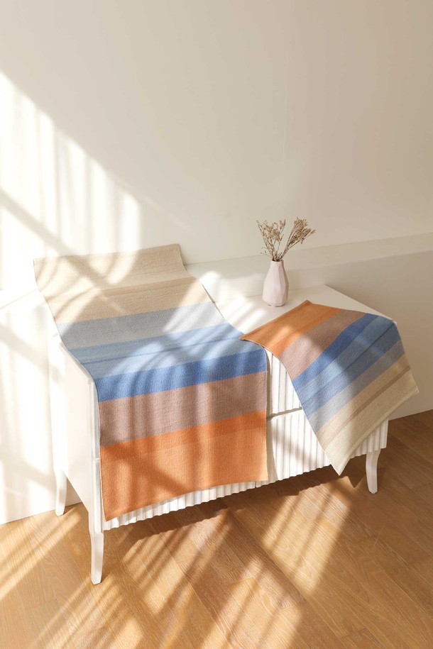 핸드메이드 면 주방매트 겸 다용도 러그 L 60x120cm 썬키스드워터는 부드러운 촉감의 핸드메이드 제품입니다. 미색, 푸른색, 하늘색, 황토색, 주황빛, 갈색 등 다채로운 컬러의 선염 면사를 사용하여 내추럴한 분위기를 연출합니다. 스트라이프 패턴과 3cm 두께로 제작되었으며, 주방, 현관, 베란다, 욕실, 침실, 아이방 등 다양한 공간에서 사용 가능합니다. 도트형 미끄럼 방지 기능과 먼지 날림이 적고, 피부 자극이 없어 안심하고 사용할 수 있는 러그 겸 매트입니다.
