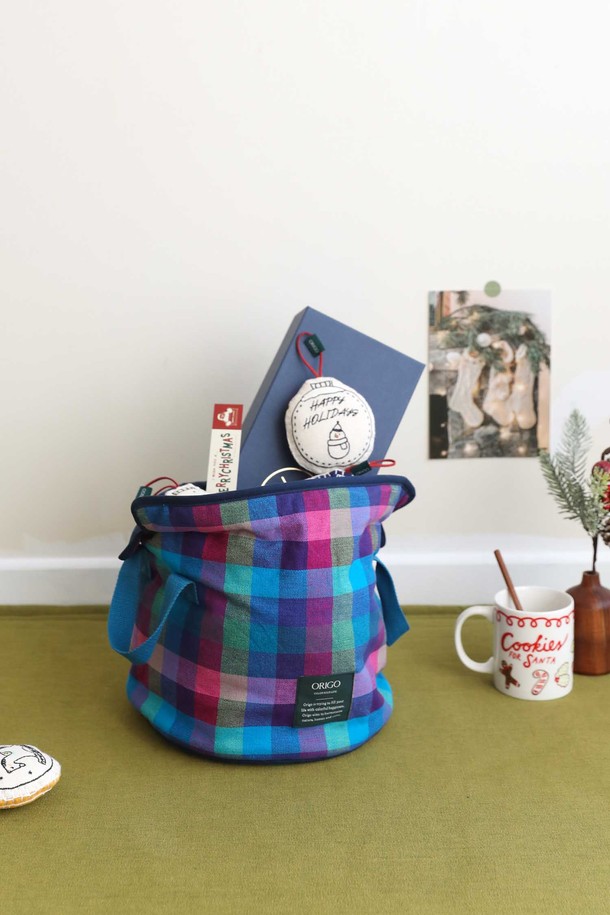 체크 패턴의 패브릭 수납 바스켓입니다. 블루, 퍼플, 핑크 3가지 컬러로 구성되어 다양한 공간에 포인트를 줄 수 있습니다. 부드러운 패브릭 소재에 귀여운 리본 손잡이가 달려있어 디자인적 요소를 더했습니다. 접이식 형태로 사용하지 않을 때는 간편하게 보관할 수 있으며, 넉넉한 수납 공간으로 정리 정돈에 용이합니다. 원통형 디자인과 양쪽 손잡이로 실용성을 높인 수납 바스켓입니다.
