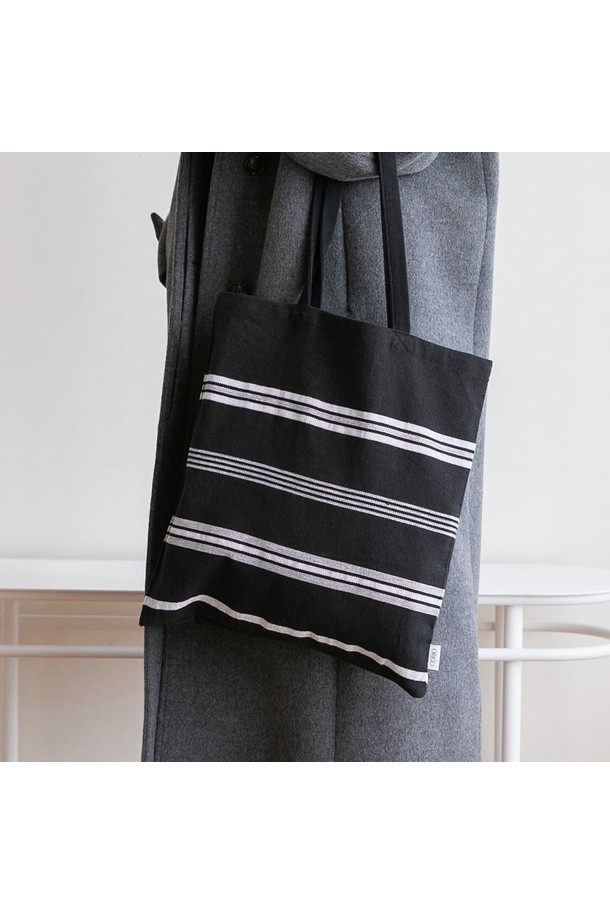 세련된 스타일의 여성용 에코백, 오가닉 코튼 사일런스 블랙입니다. 부드러운 면과 오가닉 코튼 소재로 제작되어 편안한 착용감을 선사합니다. 미디엄 사이즈의 사각형 캔버스 숄더백으로, 스트라이프 무늬가 캐주얼하면서도 미니멀한 감성을 더합니다. 넉넉한 수납 공간과 오픈형 잠금 방식으로 실용성을 높였으며, 사이즈 조절 기능으로 편리하게 사용할 수 있습니다. 일상생활에서 데일리 백으로 활용하기 좋은 아이템입니다.
