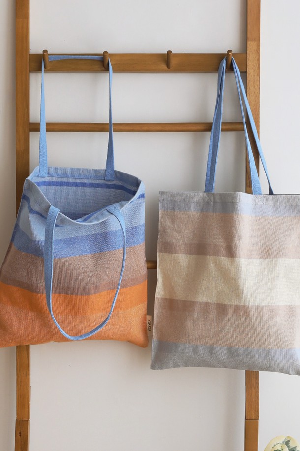 [오리고] 에코백 오가닉코튼 썬키스드워터 2종은 여성 및 남성 모두 사용 가능한 미디엄 사이즈의 에코백입니다. 블루와 베이지 두 가지 색상으로 제공되며, 오가닉 코튼 소재로 제작되어 부드러운 캔버스 두께감을 자랑합니다. A4 사이즈 수납이 가능하며, 손잡이가 있어 편리하게 사용 가능합니다. 미니멀하고 베이직한 디자인으로 쇼핑룩, 산책룩 등 다양한 TPO에 잘 어울립니다. GOTS 및 Oeko-tex Standard 100 인증을 받은 친환경 제품이며, 핸드메이드 수제 직조 방식으로 제작되어 내구성이 뛰어납니다.
