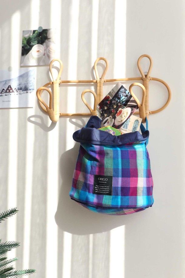 체크 패턴의 패브릭 수납 바스켓입니다. 블루, 퍼플, 핑크 3가지 컬러로 구성되어 다양한 공간에 포인트를 줄 수 있습니다. 부드러운 패브릭 소재에 귀여운 리본 손잡이가 달려있어 디자인적 요소를 더했습니다. 접이식 형태로 사용하지 않을 때는 간편하게 보관할 수 있으며, 넉넉한 수납 공간으로 정리 정돈에 용이합니다. 원통형 디자인과 양쪽 손잡이로 실용성을 높인 수납 바스켓입니다.
