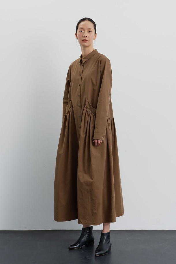 Manu (마누) 코튼 셔츠 드레스 브라운은 클래식과 미니멀 무드를 동시에 선사하는 여성 셔츠 원피스입니다. 부드러운 촉감의 면 소재로 제작되었으며, 봄, 가을, 겨울 모두 활용 가능한 중간 두께감입니다. 셔츠 칼라와 루즈핏 디자인, 맥시 기장이 편안하면서도 세련된 스타일을 연출합니다. 아웃포켓 디테일, 투톤 단추, 커프스 디테일이 돋보이며, 바이오 가공과 페이퍼라이크 코튼으로 고급스러움을 더했습니다. 모임룩으로 활용하기 좋으며, 브라운 컬러가 차분하고 우아한 분위기를 자아냅니다.
