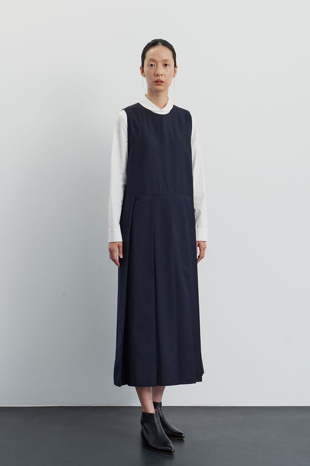 네이비 컬러의 플리츠 점퍼 원피스입니다. 가을, 겨울 시즌에 어울리는 두꺼운 두께감과 부드러운 촉감이 특징이며, 라운드넥과 민소매 디자인으로 다양한 레이어링이 가능합니다. 스트레이트 또는 루즈핏으로 연출 가능하며, 플레어 치마 타입이 여성스러운 실루엣을 강조합니다. 모던, 클래식, 미니멀한 스타일을 추구하는 분들께 추천하며, 오피스룩, 모임룩, 하객룩 등 TPO에 맞춰 시크하게 연출할 수 있습니다. 폴리에스테르와 레이온 혼방 소재로 제작되었으며 드라이클리닝을 권장합니다.
