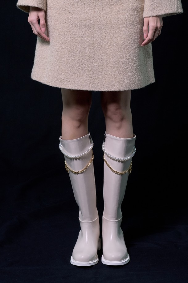 레지나 롱 부츠_B2515 (아이보리)는 여성용 롱 부츠로, 가을과 겨울에 착용하기 좋습니다. 라운드 토우 디자인에 발등을 덮는 스타일로, 합성가죽 소재를 사용하여 제작되었습니다. 굽 높이는 2.8cm 로우힐이며, 측면 지퍼로 간편하게 신고 벗을 수 있습니다. 무지 패턴에 탈부착 가능한 진주 로고 체인과 컷라인 디테일, 로고 라벨이 더해져 클래식, 미니멀, 캐주얼 스타일 모두 소화 가능하며, 데이트룩과 겨울 데일리룩에 잘 어울립니다.
