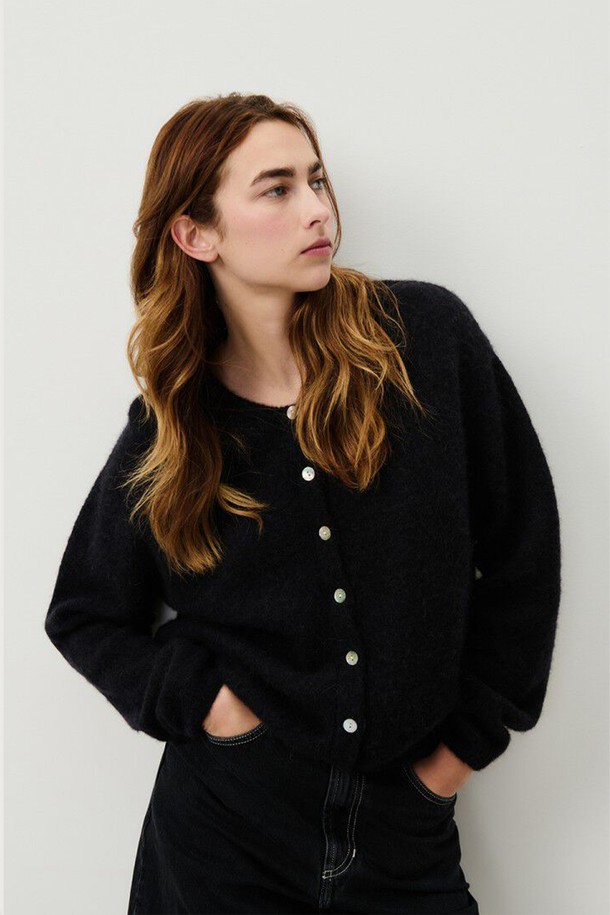 비토 가디건_누아르 블랙은 여성용 니트 가디건입니다. 가을과 겨울에 적합하며, 부드러운 알파카, 울, 폴리아미드, 엘라스틴 혼방 소재로 제작되어 두꺼운 두께감과 포근한 촉감을 선사합니다. 레귤러 핏의 레귤러 기장으로, 버튼 여밈 방식이며, 티셔츠와 레이어드하여 캐주얼, 클래식, 미니멀 스타일로 연출하기 좋습니다. 겨울 데일리룩에 활용하기 좋은 무지 블랙 컬러의 가디건입니다.
