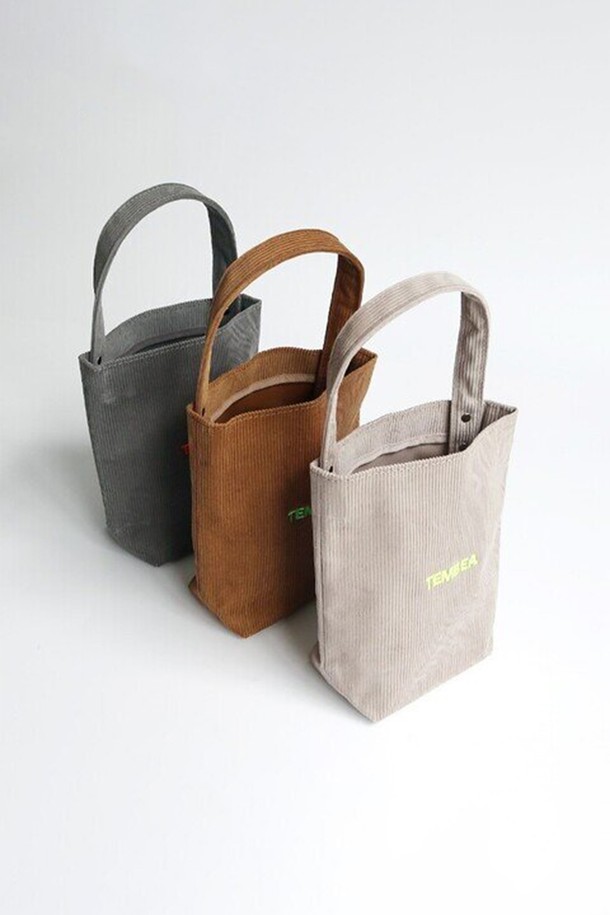 [TEMBEA] 템베아 BAGUETTE TOTE MINI CORDUROY_Lt Grey는 부드러운 코듀로이 소재로 제작된 여성용 토트백입니다. 미니멀한 디자인과 라이트 그레이 컬러가 어우러져 캐주얼하고 세련된 스타일을 연출합니다. 가방은 사각형 모양이며 오픈형으로, 간편하게 소지품을 넣고 꺼낼 수 있습니다. 일상생활에서 활용하기 좋은 실용적인 아이템으로, 미니멀하고 캐주얼한 스타일을 선호하는 분들께 추천합니다. 바게트 스타일의 디자인이 돋보이는 템베아 토트백입니다.
