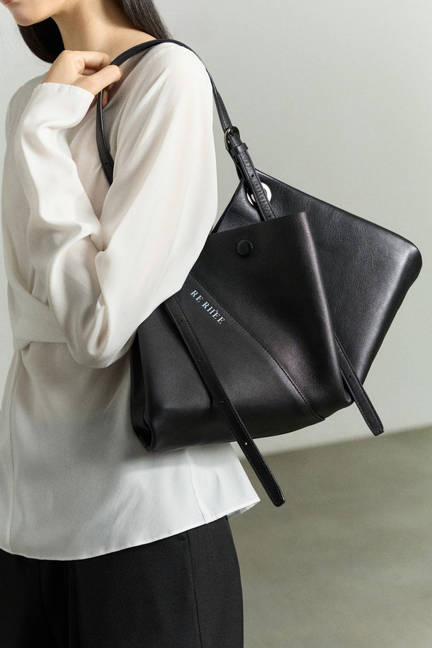 **ADJUSTABLE STRAP LEATHER BAG BLACK (어저스터블 스트랩 레더 백 블랙)**은 미니멀하고 모던한 감각을 더한 여성용 토트백입니다. 소가죽, 폴리에스터, 폴리우레탄 소재로 제작되었으며, 블랙 컬러와 로고 패턴으로 시크한 매력을 선사합니다. 3-4가지 스타일 변형이 가능하여 토트백, 숄더백, 벨트백, 슬링백으로 활용할 수 있으며, 드레이핑 디자인과 하이엔드 무드를 연출합니다. 길이 조절 가능한 스트랩과 RE RH'EE 로고 디테일, 사선 절개 디테일이 특징이며, 출근룩과 오피스룩에 잘 어울립니다. 미디엄 사이즈로 일상에서 실용적으로 사용할 수 있습니다.

