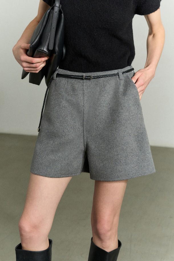 캐시미어 울 숏 그레이 팬츠는 여성스러운 실루엣을 강조하는 A라인 숏 쇼츠입니다. 가을, 겨울 시즌에 어울리는 고급스러운 캐시미어, 울 혼방 소재로 제작되어 부드러운 터치감을 선사합니다. 하이웨이스트 핏으로 다리가 길어 보이는 효과를 주며, 안감이 있어 편안하게 착용 가능합니다. 은은한 광택감과 벨트고리, 콘솔 지퍼 여밈, 주머니 디테일이 더해져 데일리룩, 오피스룩, 모임룩 등 다양한 TPO에 활용 가능합니다. 미니멀하고 시크한 스타일을 연출하기에 좋습니다.
