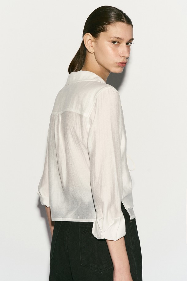 TIE FRONT 레이어드 셔츠는 여성스러운 무드를 연출하는 셔츠/블라우스입니다. 부드러운 촉감의 레이온, 실크, 폴리에스테르 혼방 소재로 제작되어 봄, 여름 시즌에 시원하게 착용하기 좋습니다. 은은한 광택감이 돋보이는 화이트 컬러에 이중 레이어드 디자인과 리본 디테일, 자개 로고 버튼 장식이 더해져 모던하면서도 엘레강스한 스타일을 완성합니다. 레귤러핏과 숄카라, 긴 소매, 크롭 기장으로 디자인되었으며, 데이트룩, 카페룩, 모임룩 등 다양한 TPO에 클래식, 미니멀, 로맨틱 스타일로 코디하기 좋습니다.
