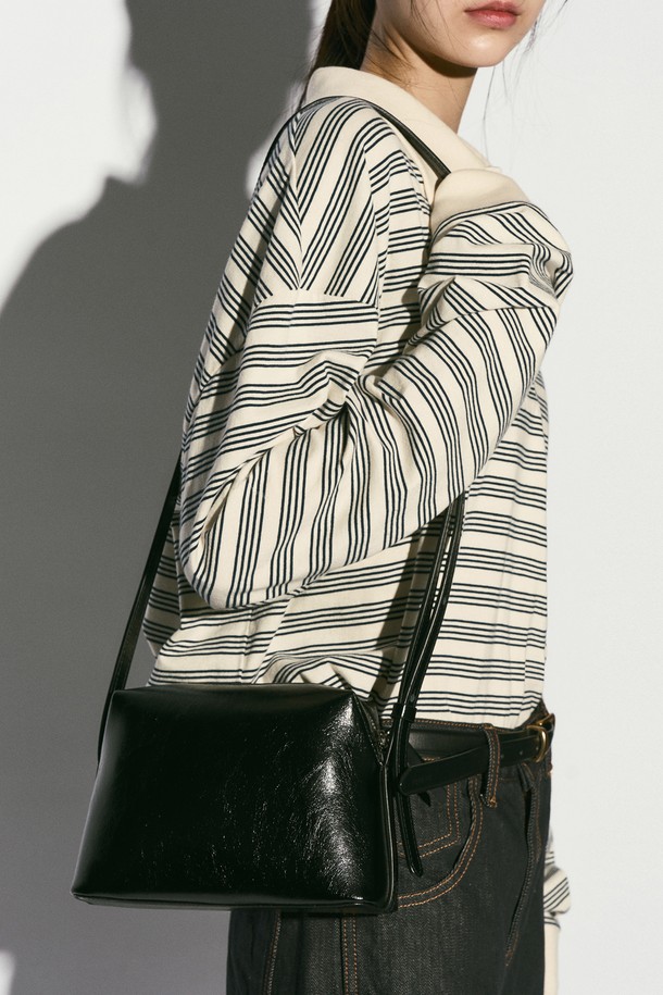 스퀘어 크로스바디 백 블랙은 부드러운 소가죽 소재로 제작되어 빈티지하면서도 클래식한 무드를 자아내는 여성용 크로스백입니다. 내부에는 오픈 포켓이 있어 실용성을 높였으며, 시그니처 로고 인쇄와 내부 로고 가죽 바인딩 디테일로 고급스러움을 더했습니다. 가방 모양은 사각형이며, 지퍼형 잠금 방식으로 소지품을 안전하게 보관할 수 있습니다. 길이 조절 가능한 스트랩으로 다양한 스타일 연출이 가능하며, 출근룩과 모임룩에 모두 잘 어울립니다. 모던하면서도 시크한 스타일을 추구하는 분들께 추천합니다.
