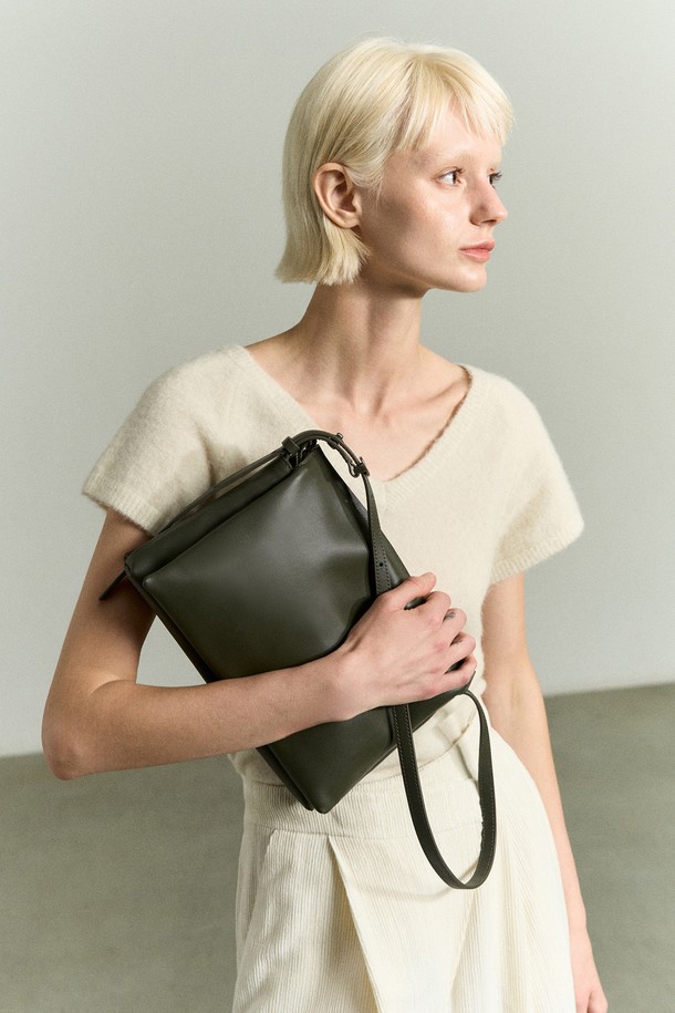 세련된 스타일을 완성하는 TRIO 레더Bag 카키입니다. 부드러운 소가죽과 나파레더 소재로 제작되어 고급스러운 질감을 선사하며, 여성스러운 오피스룩, 출근룩, 모임룩에 잘 어울립니다. 미디엄 사이즈로 실용적인 수납력을 자랑하며, 가방 내부 3칸 구조와 스트랩으로 편의성을 더했습니다. 무지 디자인에 로고 장식으로 포인트를 주어 클래식, 미니멀, 시크한 스타일을 연출할 수 있습니다. 세탁은 가죽 전문점에 맡겨 관리해주시고, 코튼 안감으로 섬세함을 더했습니다.
