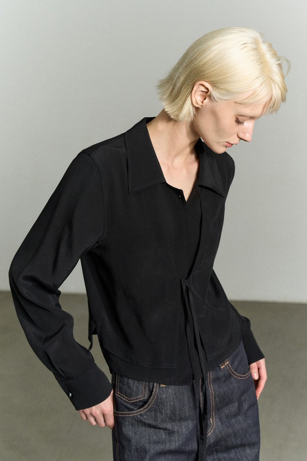 프론트 타이 레이어드 셔츠 블라우스 블랙은 시크, 로맨틱, 모던 스타일을 모두 아우르는 여성 의류입니다. 부드러운 레이온 소재로 제작되었으며, 앞판 이중 레이어드 디자인과 리본 디테일이 특징입니다. 와이드 카라와 세미 크롭 기장으로 세련된 실루엣을 연출하며, 긴 소매로 FW 시즌에도 따뜻하게 착용할 수 있습니다. 리얼 자개 로고 버튼과 비침 방지 레이어드로 고급스러움을 더했습니다. 데이트룩, 모임룩, 오피스룩 등 다양한 TPO에 활용하여 시크하고 클래식하며 미니멀한 스타일을 완성해보세요.

