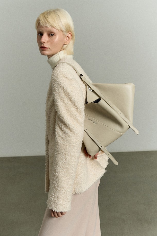 아이보리 베이지 컬러의 ADJUSTABLE STRAP LEATHER BAG(어저스터블 스트랩 레더 백)은 RE RH'EE 컬렉션의 하이엔드 무드를 담은 토트백입니다. 소가죽, 폴리에스터, 폴리우레탄 소재로 제작되었으며, 사선 절개 디테일과 로고 패턴이 특징입니다. 미디엄 사이즈로 토트백, 숄더백, 벨트백, 슬링백 등 3-4가지 스타일로 변형 가능하며 사이즈 조절이 용이합니다. 오피스룩, 모임룩, 소개팅룩 등 다양한 TPO에 맞춰 클래식, 미니멀, 시크한 스타일을 연출할 수 있는 사각 쉐입의 가방입니다.
