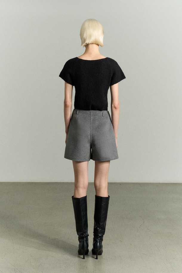 캐시미어 울 숏 그레이 팬츠는 여성스러운 실루엣을 강조하는 A라인 숏 쇼츠입니다. 가을, 겨울 시즌에 어울리는 고급스러운 캐시미어, 울 혼방 소재로 제작되어 부드러운 터치감을 선사합니다. 하이웨이스트 핏으로 다리가 길어 보이는 효과를 주며, 안감이 있어 편안하게 착용 가능합니다. 은은한 광택감과 벨트고리, 콘솔 지퍼 여밈, 주머니 디테일이 더해져 데일리룩, 오피스룩, 모임룩 등 다양한 TPO에 활용 가능합니다. 미니멀하고 시크한 스타일을 연출하기에 좋습니다.
