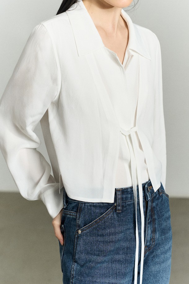 세련된 무드의 FRONT-TIE 레이어드 셔츠 블라우스 화이트입니다. 부드러운 레이온 소재로 제작되어 편안한 착용감을 선사하며, 앞판 이중 레이어드 구조와 리본 디테일이 여성스러운 포인트를 더합니다. 와이드 카라 디자인과 레귤러핏으로 어떤 스타일에도 잘 어울리며, 가을, 겨울 시즌 데이트룩, 카페룩, 모임룩과 같은 TPO에 맞춰 클래식, 미니멀, 로맨틱 스타일을 연출할 수 있습니다. 비침 방지 기능과 자개 로고 버튼으로 고급스러운 마감 처리를 하였으며, 긴 소매 기장과 얇은 두께감으로 레이어드하여 다양한 스타일링을 즐기기 좋습니다.
