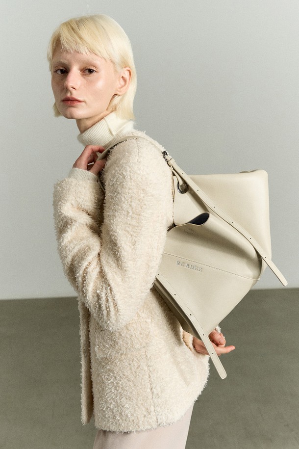 아이보리 베이지 컬러의 ADJUSTABLE STRAP LEATHER BAG(어저스터블 스트랩 레더 백)은 RE RH'EE 컬렉션의 하이엔드 무드를 담은 토트백입니다. 소가죽, 폴리에스터, 폴리우레탄 소재로 제작되었으며, 사선 절개 디테일과 로고 패턴이 특징입니다. 미디엄 사이즈로 토트백, 숄더백, 벨트백, 슬링백 등 3-4가지 스타일로 변형 가능하며 사이즈 조절이 용이합니다. 오피스룩, 모임룩, 소개팅룩 등 다양한 TPO에 맞춰 클래식, 미니멀, 시크한 스타일을 연출할 수 있는 사각 쉐입의 가방입니다.
