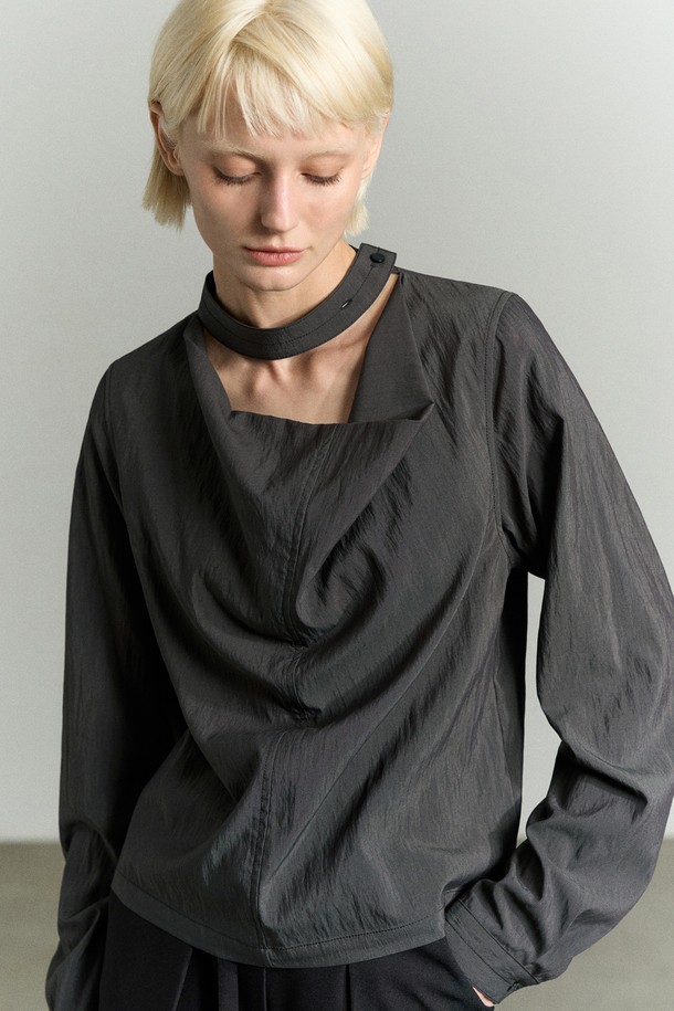 "넥 디테일 드레이핑 블라우스"는 우아함과 모던함을 동시에 표현하는 여성 블라우스입니다. 부드러운 레이온과 나일론 혼방 소재로 제작되어, 은은한 광택감과 부드러운 촉감을 선사합니다. 얇은 두께감으로 사계절 내내 활용 가능하며, 카울넥 디자인과 타이 디테일이 특징입니다. 구김이 적어 관리가 용이하며, 2버튼으로 사이즈 조절이 가능하고, 커프스 단추 디테일로 고급스러움을 더했습니다. 오피스룩, 모임룩, 소개팅룩 등 다양한 TPO에 맞춰 클래식, 미니멀, 시크한 스타일을 연출해보세요.
