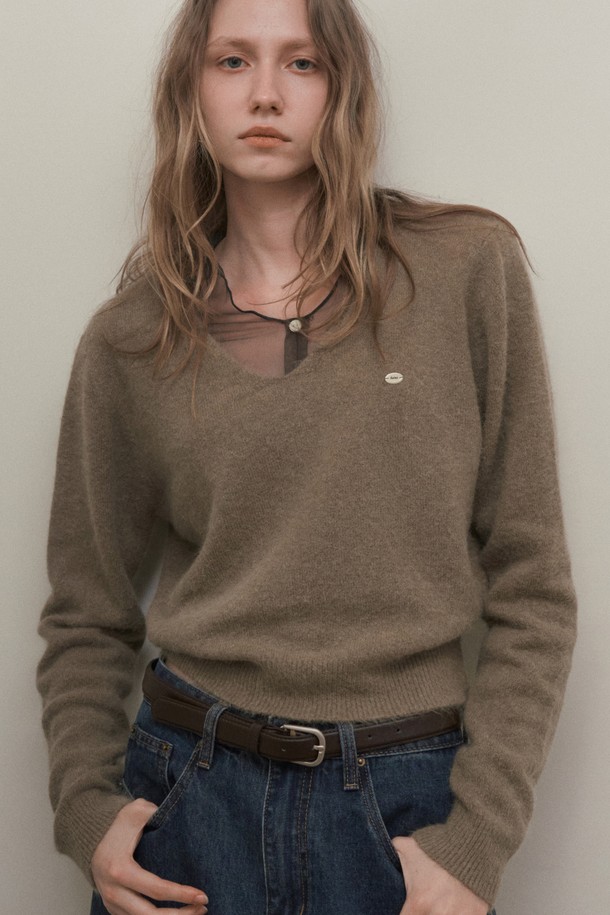 SEREN 브이넥 앙고라 니트_모카 브라운은 여성 의류로, 가을과 겨울에 어울리는 니트/스웨터입니다. 앙고라 혼방 소재로 제작되어 부드러운 촉감과 가벼운 중량감을 자랑하며, 높은 보온성을 제공합니다. 미니멀하고 베이직한 디자인으로 다양한 스타일 연출이 용이하며, 데이트룩 및 출근룩에 적합합니다. 파스텔톤 모카 브라운 컬러와 릴랙스 핏, 긴 소매, 브이넥 디자인이 특징입니다.
