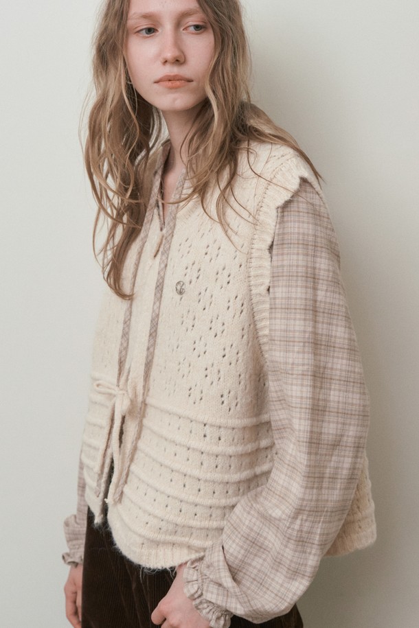 펀칭 스카프 세트 베스트_아이보리는 울, 아크릴, 폴리에스테르 혼방 소재의 여성용 겨울 베스트입니다. 레트로와 빈티지 스타일을 결합한 디자인으로, 펀칭 니트 패턴과 라운드넥, 민소매 디자인이 특징입니다. 부드러운 촉감과 두꺼운 두께로 뛰어난 보온성을 제공하며, 스카프 세트 구성으로 다양한 스타일 연출이 가능합니다. 오버핏으로 편안하게 착용할 수 있으며, 일상복으로 활용하기 좋습니다.
