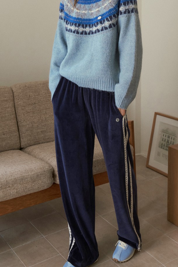 네이비 컬러의 벨벳 릴렉스드 트랙 팬츠는 편안함과 스타일을 모두 갖춘 제품입니다. 부드러운 벨벳 소재로 제작되어 뛰어난 착용감을 선사하며, 릴렉스핏으로 활동성을 높였습니다. 넉넉한 두께감으로 가을, 겨울철 따뜻하게 입을 수 있으며, 사이드 라인 디테일이 스포티한 무드를 더합니다. 허리 밴딩 처리로 편안하게 착용 가능하며, 캐주얼부터 스포티한 스타일까지 폭넓게 활용할 수 있습니다.
