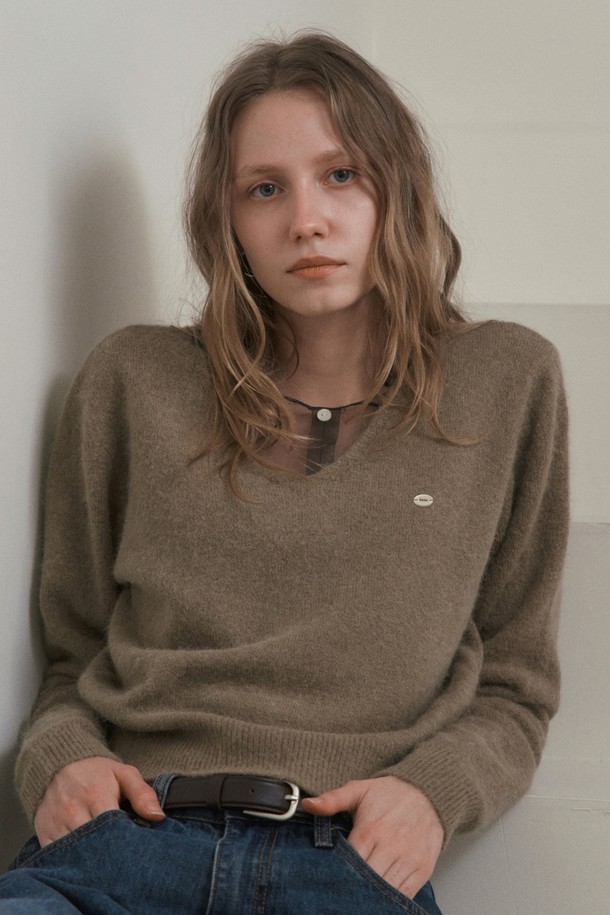 SEREN 브이넥 앙고라 니트_모카 브라운은 여성 의류로, 가을과 겨울에 어울리는 니트/스웨터입니다. 앙고라 혼방 소재로 제작되어 부드러운 촉감과 가벼운 중량감을 자랑하며, 높은 보온성을 제공합니다. 미니멀하고 베이직한 디자인으로 다양한 스타일 연출이 용이하며, 데이트룩 및 출근룩에 적합합니다. 파스텔톤 모카 브라운 컬러와 릴랙스 핏, 긴 소매, 브이넥 디자인이 특징입니다.
