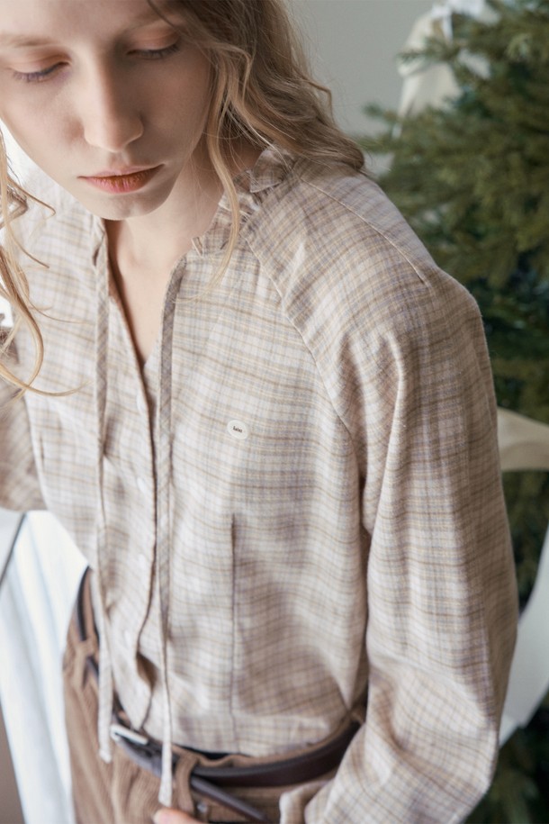 베이지 컬러의 RUFFLE CHECK 크롭 블라우스입니다. 부드러운 면 소재로 제작되어 봄, 가을에 착용하기 좋으며, 페미닌하고 우아한 스타일을 연출합니다. 러플 넥 라인과 리본 디테일이 여성스러운 분위기를 더하고, 래글런 소매와 어깨 다트 디테일, 플레어 밑단으로 편안하면서도 세련된 핏을 선사합니다. 데이트룩, 클래식, 로맨틱, 미니멀 스타일을 즐겨 입는 여성분들께 추천합니다. 루즈핏의 크롭 기장으로 다리가 길어 보이는 효과를 줍니다.
