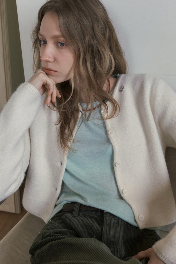 BERY 앙고라 크롭 가디건_아이보리는 여성 의류로, 가을과 겨울에 따뜻하게 입을 수 있는 제품입니다. 부드러운 촉감의 앙고라 소재를 사용하여 포근함을 더했으며, 베이직하고 미니멀한 스타일로 다양한 룩에 활용하기 좋습니다. 라운드넥에 긴소매, 레귤러핏으로 디자인되었으며, 크롭 기장과 버튼 여밈 방식이 특징입니다. 데이트룩, 모임룩 등 TPO에 맞춰 클래식, 미니멀, 캐주얼 스타일을 연출할 수 있습니다.
