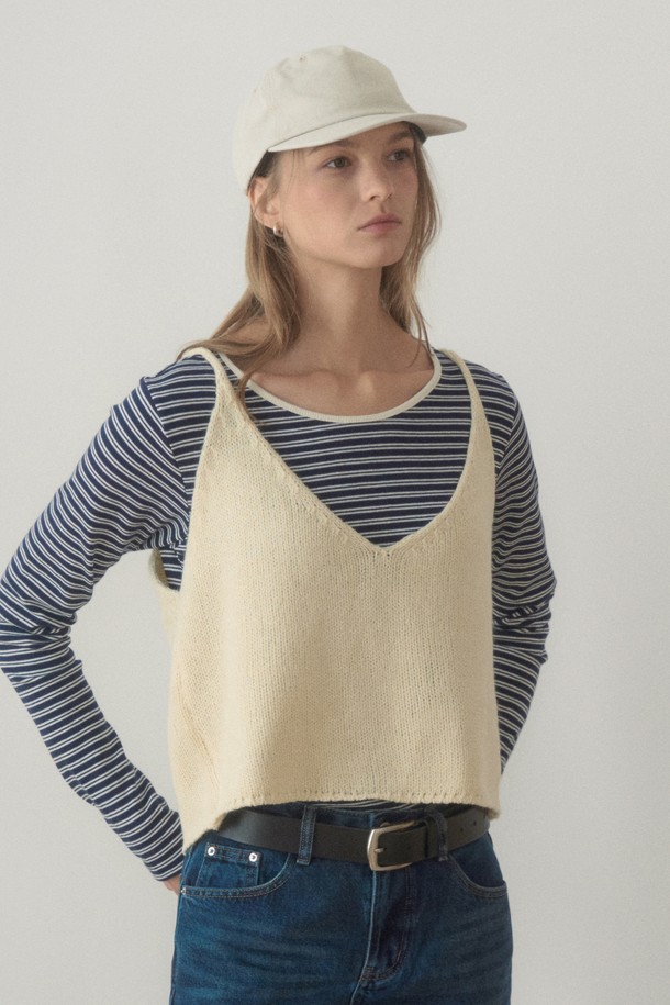 아이보리 컬러의 REAR STRING KNIT VEST(리어 스트링 니트 베스트)입니다. 부드러운 촉감의 니트 소재로 제작되어 봄, 가을 간절기에 활용하기 좋습니다. 크롭 기장의 민소매 디자인으로 캐주얼하고 베이직한 스타일을 연출하며, V넥 라인과 백 리본, 스트링 디테일이 특징입니다. 데이트룩이나 봄 소풍룩에 매치하여 여성스러운 분위기를 더할 수 있습니다. 미니멀, 클래식 스타일을 즐겨 입는 분들께 추천합니다.
