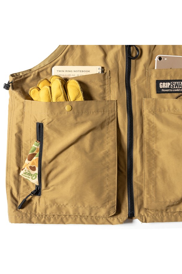 [GSMV-063] 기어 백 베스트 5.0 코요테는 아웃도어 및 일상에서 활용하기 좋은 남성용 베스트입니다. 밀리터리, 아웃도어 스타일을 연출하며, 사계절 착용 가능한 레귤러 기장의 민소매 디자인입니다. 나일론과 폴리에스테르 혼방 소재로 제작되어 튼튼하며, 무지 패턴의 코요테 컬러가 특징입니다. 라운드넥에 지퍼형 여밈 방식으로, 다양한 소지품을 수납할 수 있는 다수의 포켓과 토트백으로 변형 가능한 2WAY 디자인을 제공합니다. 여행, 캠핑, 등산 등 다양한 TPO에 캐주얼, 고프코어, 워크웨어 스타일로 활용하기 좋습니다.
