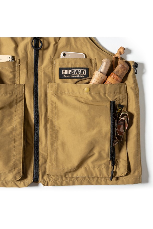 [GSMV-063] 기어 백 베스트 5.0 코요테는 아웃도어 및 일상에서 활용하기 좋은 남성용 베스트입니다. 밀리터리, 아웃도어 스타일을 연출하며, 사계절 착용 가능한 레귤러 기장의 민소매 디자인입니다. 나일론과 폴리에스테르 혼방 소재로 제작되어 튼튼하며, 무지 패턴의 코요테 컬러가 특징입니다. 라운드넥에 지퍼형 여밈 방식으로, 다양한 소지품을 수납할 수 있는 다수의 포켓과 토트백으로 변형 가능한 2WAY 디자인을 제공합니다. 여행, 캠핑, 등산 등 다양한 TPO에 캐주얼, 고프코어, 워크웨어 스타일로 활용하기 좋습니다.
