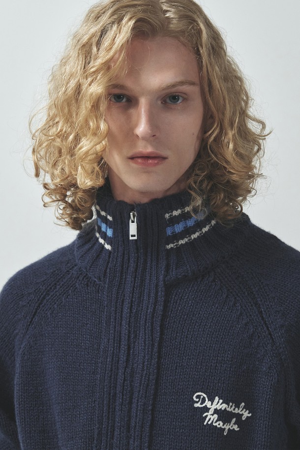 유스 프래그먼트 코위찬 집업_네이비는 가을, 겨울 시즌 남성들을 위한 캐주얼, 스트릿 스타일의 상의입니다. 5게이지 고밀도 울, 아크릴 혼방 소재로 제작되어 두꺼운 두께감과 뻣뻣한 촉감을 선사하며, 하이넥 디자인과 투웨이 지퍼 여밈으로 보온성을 높였습니다. 

라글란 슬리브, 코위찬 스타일의 디자인이 특징이며, 앞면과 뒷면에 체인 자수 디테일이 더해져 포인트를 줍니다. 레귤러핏으로 제작되어 편안한 착용감을 제공하며, 겨울 데일리룩, 모임룩 등 다양한 TPO에 활용 가능합니다. 네이비 컬러로 어떤 스타일에도 쉽게 매치할 수 있습니다.
