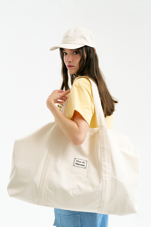 아이보리 컬러의 [Plan de Maroon] 로고 빅백은 여성들을 위한 면 소재의 넉넉한 사이즈 가방입니다. 사각 형태에 박스 로고 패치 디자인이 돋보이며, 캐주얼하고 베이직한 스타일을 연출하기에 좋습니다. 일상에서 활용하기 좋으며, 스트랩 길이 57cm, 가로 72cm, 세로 46cm, 깊이 11cm의 넉넉한 수납 공간을 제공합니다.
