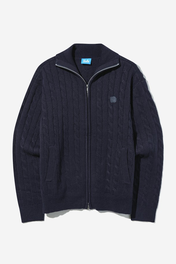 네이비 컬러의 남녀공용 케이블 터틀넥 스웨터 집업입니다. 아크릴과 폴리에스테르 혼방 소재로 제작되어 부드러운 촉감과 두꺼운 두께감으로 따뜻하게 착용 가능하며, 루즈핏 디자인과 와플 패치 디테일이 캐주얼한 스타일을 연출합니다. 봄, 가을, 겨울 시즌에 활용하기 좋으며, 오버사이즈 니트 디자인으로 편안한 착용감을 선사합니다. FFF 사이즈는 여성용 크롭 핏으로 제공됩니다.
