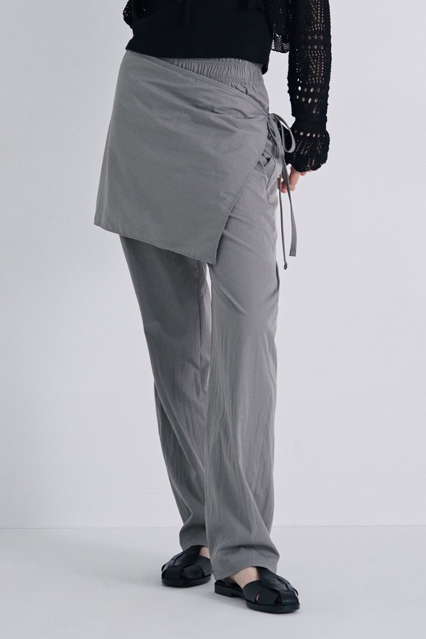 **여성 랩 스타일 와이드 팬츠(HB4LPA1)는** 부드러운 촉감의 나일론과 폴리에스테르 혼방 소재로 제작되어 봄, 가을에 착용하기 좋은 긴 기장의 와이드 팬츠입니다. 스커트 레이어드 디자인과 랩 스타일이 특징이며, 블랙, 그레이 두 가지 색상으로 제공됩니다. 레귤러핏에 밴딩 처리되어 편안하게 착용할 수 있으며, 가볍고 미니멀한 디자인으로 일상복으로 활용하기 좋습니다.
