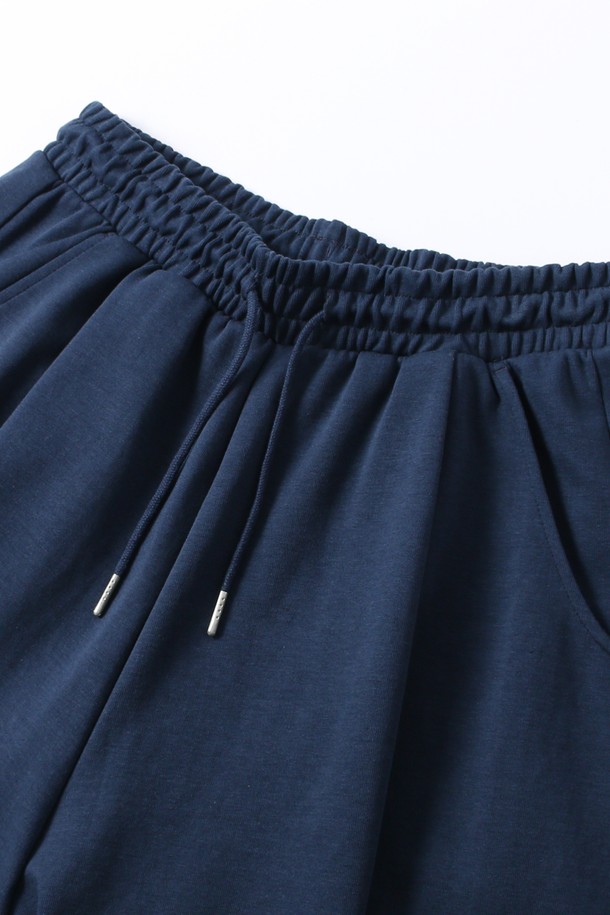 다크블루 색상의 남녀공용 풀밴딩 원턱 버뮤다 팬츠입니다. 넉넉한 루즈핏으로 편안한 착용감을 선사하며, 여름철 캐주얼, 미니멀, 리조트 스타일을 연출하기 좋습니다. 여행, 휴가, 바캉스룩에 활용하기 좋은 5부 기장의 버뮤다 팬츠는 무지 디자인으로 어떤 상의와도 쉽게 매치됩니다. 풀밴딩 허리 디자인과 원턱 디테일로 활동성을 높였습니다.
