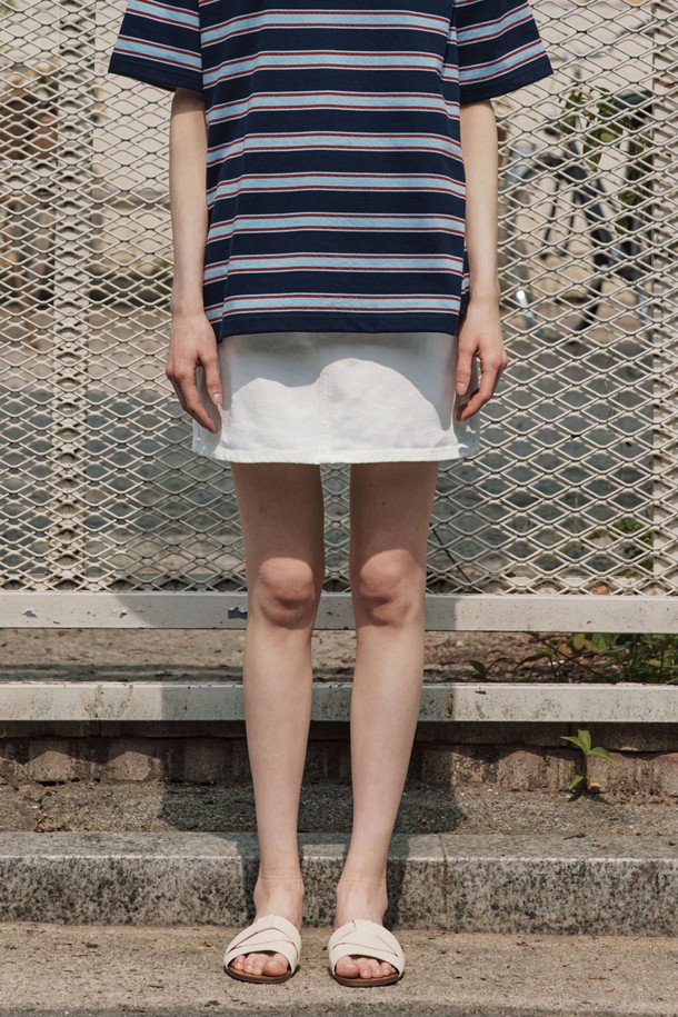 화사한 화이트 컬러의 데님 미니스커트입니다. H라인으로 떨어지는 슬림핏 디자인에 뻣뻣한 촉감의 데님 소재로 제작되어 시크한 무드를 연출합니다. 은색 리벳과 버튼 디테일이 더해져 미니멀하면서도 클래식한 스타일을 완성하며, 봄, 여름 시즌 일상룩에 활용하기 좋습니다.
