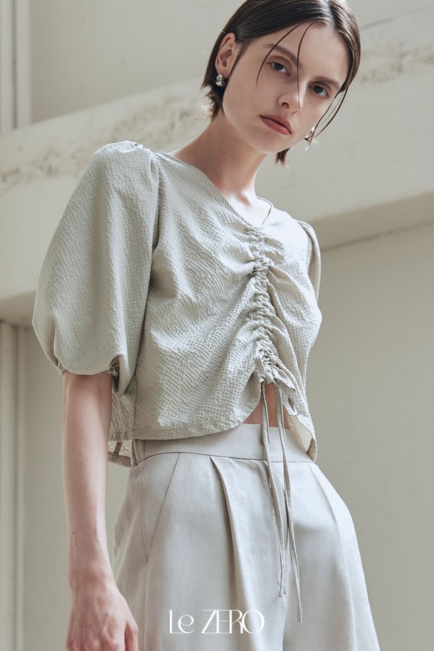 르제로 시어서커 스트링 블라우스는 카키 베이지 컬러의 여성 블라우스입니다. 봄, 여름 시즌에 어울리는 이 블라우스는 브이넥 디자인에 편안한 핏으로 우아한 스타일을 연출합니다. 볼륨감 있는 퍼프 소매와 소매 끝 밴딩 처리, 전면 스트링 디테일이 특징이며, 폴리에스테르 소재의 시어서커 패턴으로 제작되었습니다.
